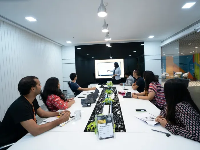 Presenter leading a team workshop in a modern conference room, representing business listings on CityDirectoryLink
